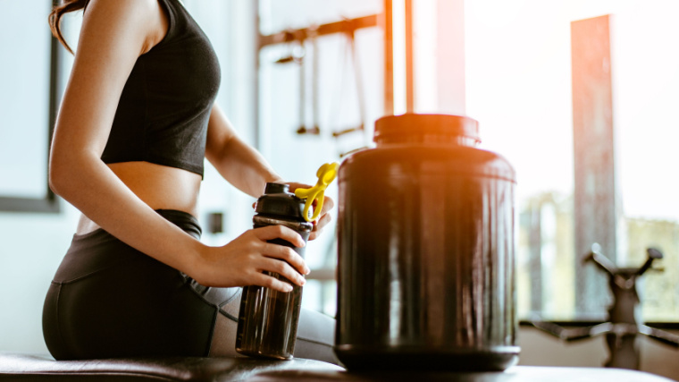 Person in gym mixing protein shake