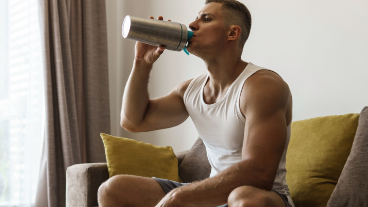 Person on couch drinking protein shake