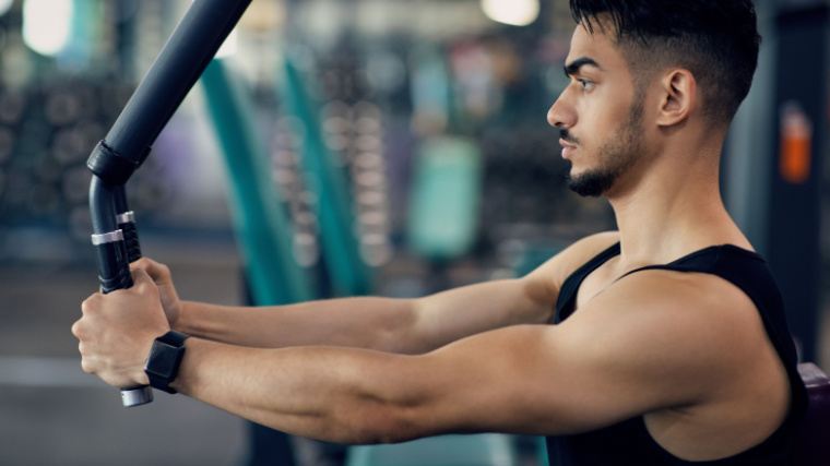 Person in gym doing chest exercise on machine