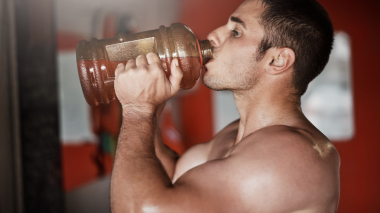 muscular person in gym drinking shake