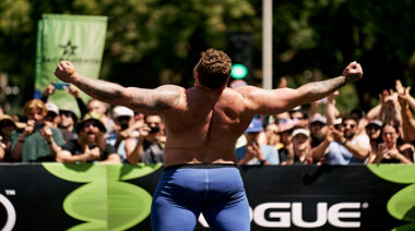 Strongman Tom Stoltman facing crowd flexing muscles