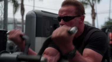 Arnold Schwarzenegger doing machine biceps curl