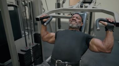 Bodybuilder Dexter Jackson performs chest press exercise on machine