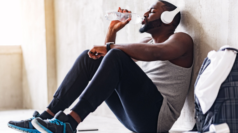 Muscular person in gym drinking water