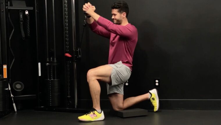 Coach James Shapiro performing half-kneeling Pallof press with lift