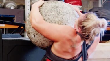 Strongwoman competitor lifting Atlas stone