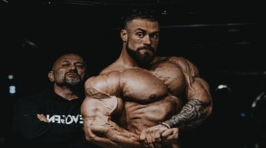 Chris Bumstead flexing with Hany Rambod May 2023