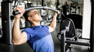 Person in gym doing lat pulldown exercise