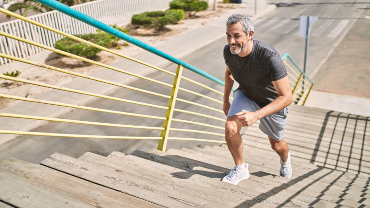 gray-haired person walking up stairs outdoors