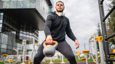 Person outdoors exercising with kettlebell