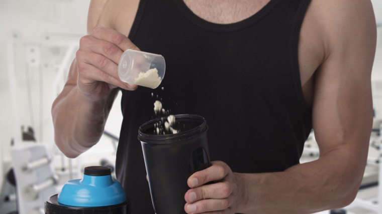 muscular person scooping protein