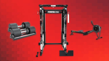 Adjustable dumbbells, Concept2 rower, and a functional trainer on a red background