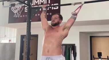 CrossFit athlete Casey Acree performs pull-ups in gym