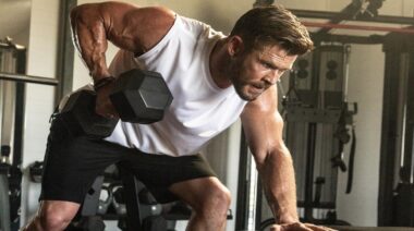 Actor Chris Hemsworth in gym performing dumbbell row