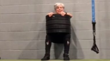 Powerlifter Mary Duffy in gym performing wall sit exercise