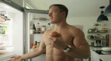 Noah Ohlsen holding apple in front of fridge 2023