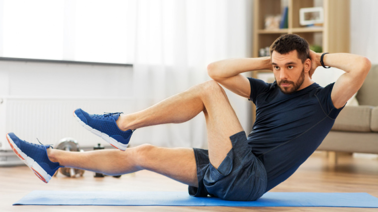 person in home gym doing bicycle crunch