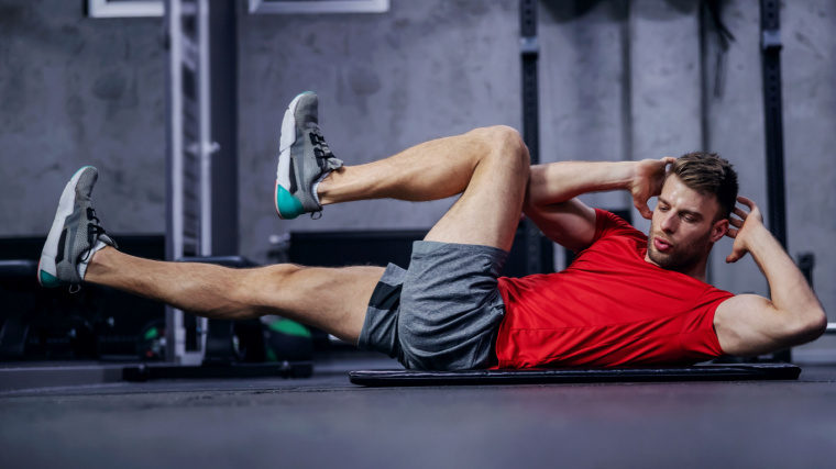 Muscular person in gym doing bicycle crunch