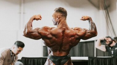 Chris Bumstead flexing arms 2023