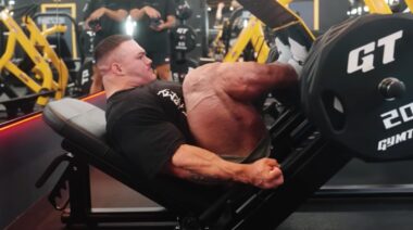 Bodybuilder Nick Walker in gym using leg press machine