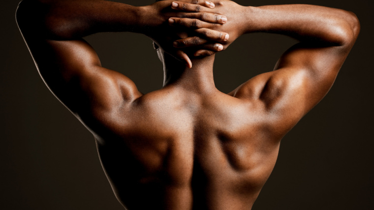 Muscular person flexing back and shoulder muscles