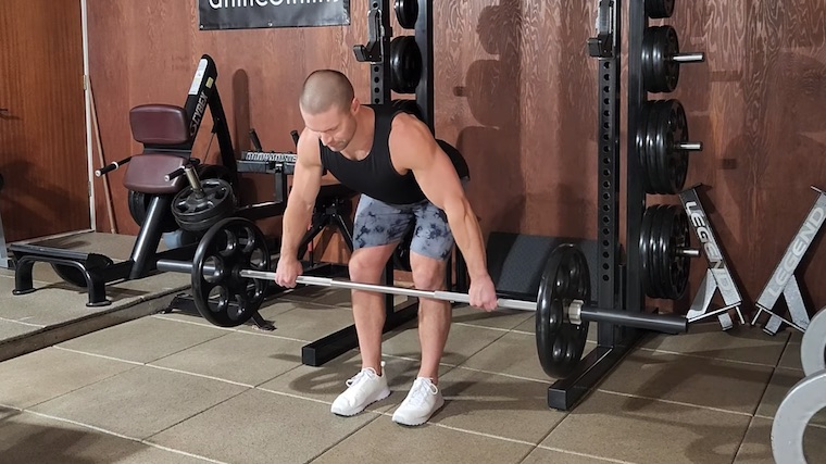 Dr. Merrick Lincoln in gym demonstrating barbell row