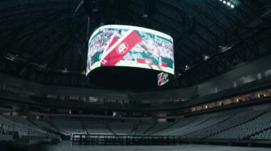 Inside view of empty stadium arena with CrossFit sport playing on overhead screen
