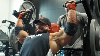 Bodybuilder Hunter Labrada in gym performing machine shoulder press.