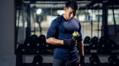 Person in gym holding protein shaker bottle