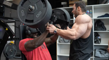 Samson Dauda performing incline press movement with assistance from fellow professional bodybuilder Michael Daboul.
