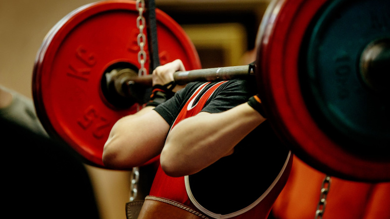 powerlifter performing squat in contest