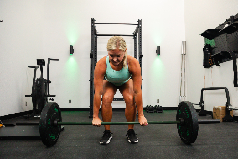 A blonde woman doing deadlifts with the REP Colorado Bar