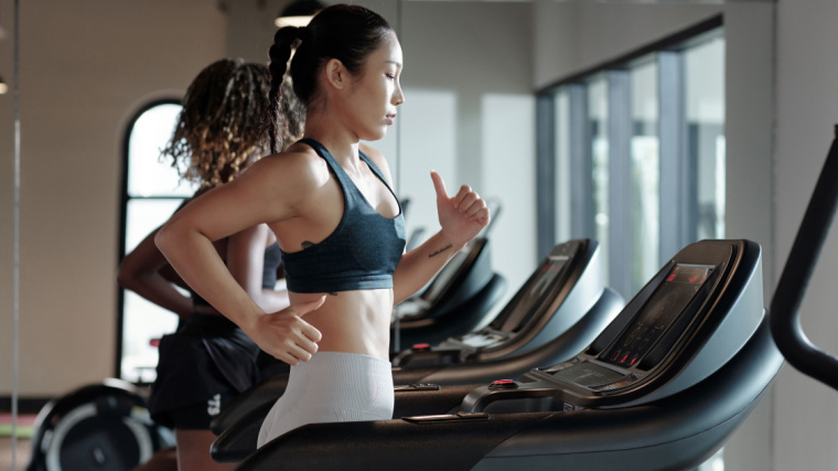 Long-haired person running on treadmill