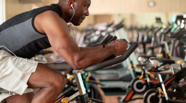 Muscular person in gym on stationary bike