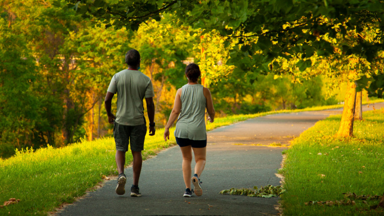 Two people walking outdoors in park