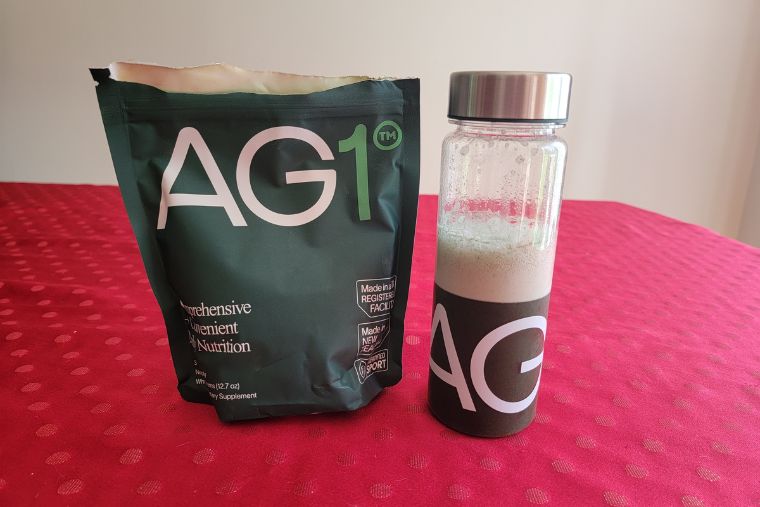 Athletic Greens AG1 pouch and the powder mixed in the AG1 bottle
