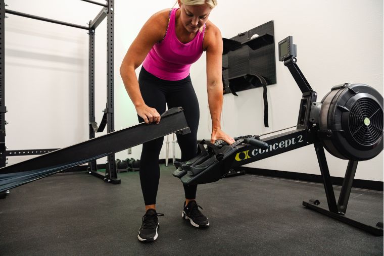 A woman breaking down the Concept2 rower into two pieces