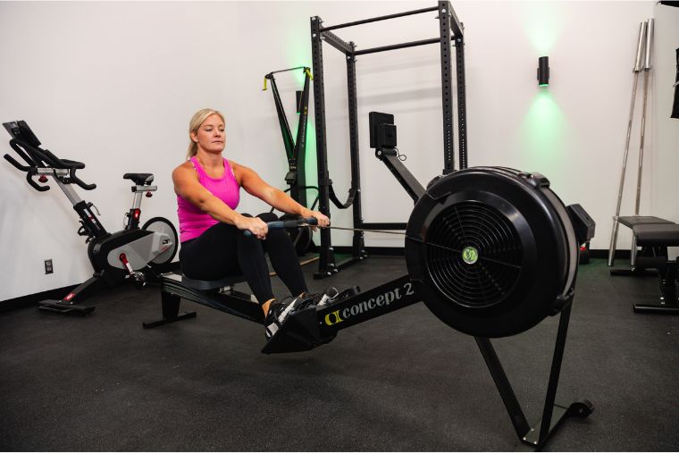 A blonde woman rowing on the Concept2 rower
