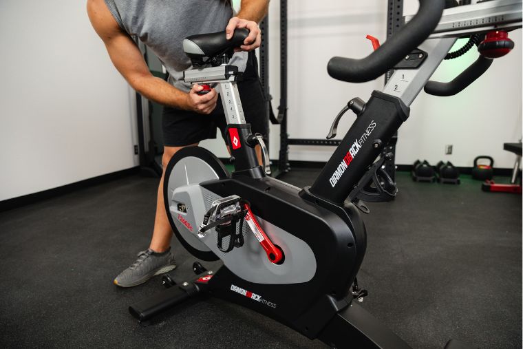 A young man adjusting the seat on the Diamondback 1260sc