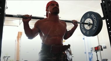 CrossFit athlete Josh Bridges performs a barbell back squat in his home gym.