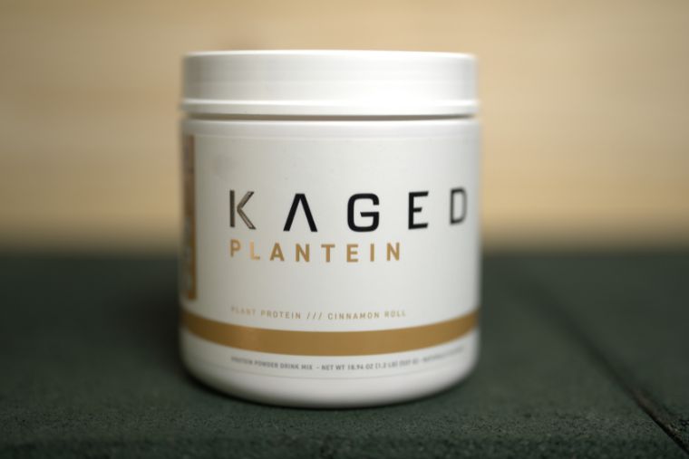 A container of Kaged Plantein in front of a wood background