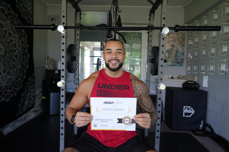 Personal trainer Stephen Sheehan holding his certificate from the ISSA.
