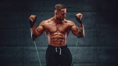 Man performing biceps curls with a resistance band.