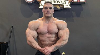 Nick Walker posing for a photo while flexing his upper body muscles.