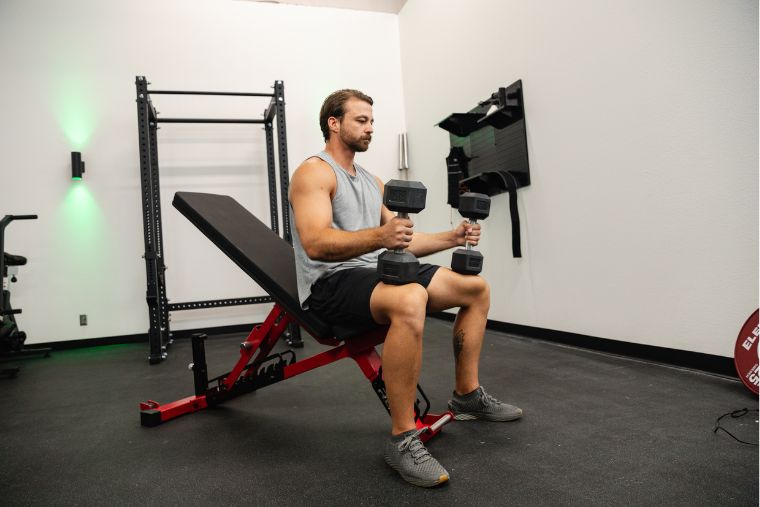 Un athlète masculin se préparant à faire des développé couché avec haltères sur le REP Fitness AB-5200 2.0