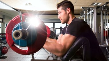 Man performs a preacher curl in the gym.