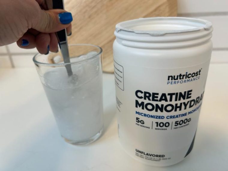 Stirring Nutricost Creatine Monohydrate into a glass of water