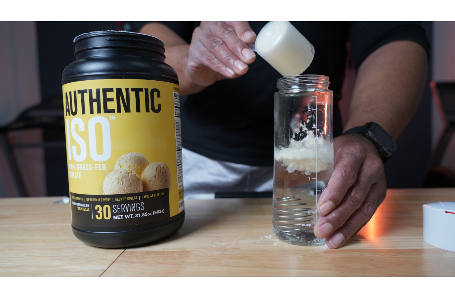 Man scooping Jacked Factory Authentic Iso into a shaker bottle.