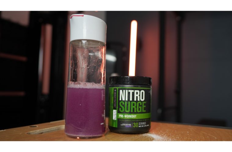 Filled shaker bottle next to a front-facing container of Jacked Factory NitroSurge 