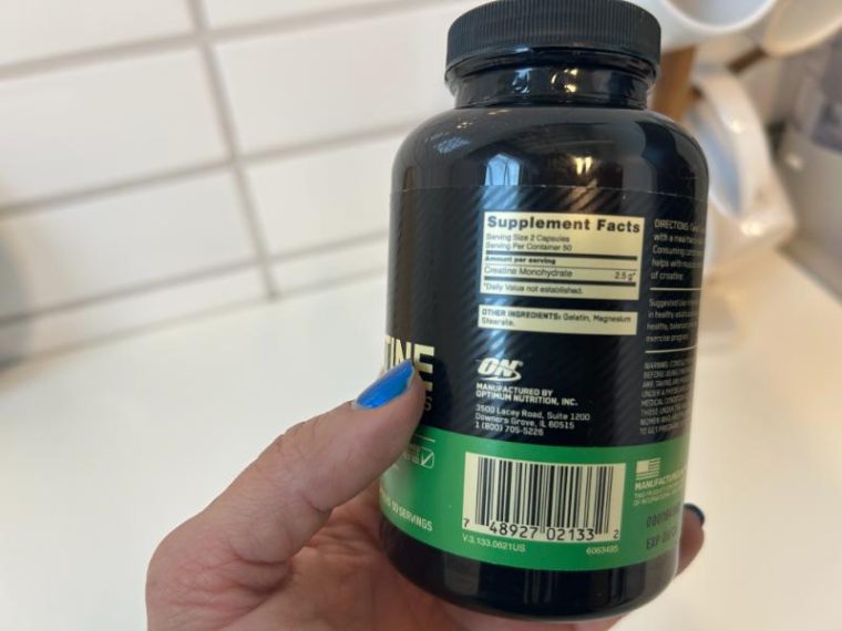 Woman holding an Optimum Nutrition Creatine Capsules bottle